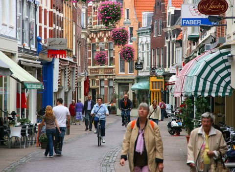 Een drukke winkelstraat in haarlem waar mensen aan het winkelen zijn